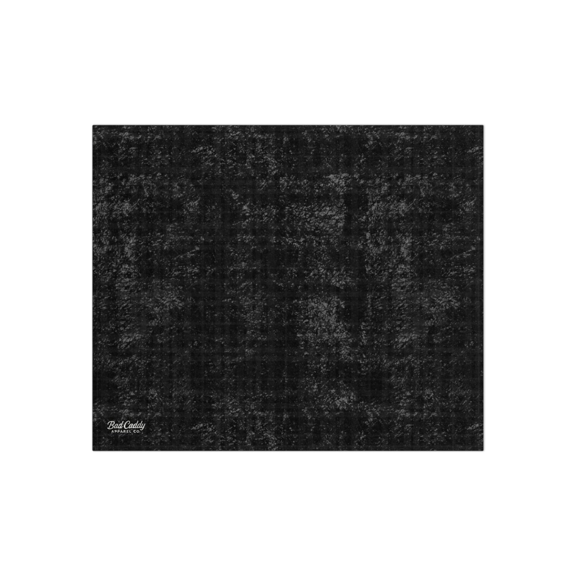 Black textured rug with a brand logo in the corner on a white background