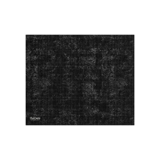 Black textured rug with a brand logo in the corner on a white background